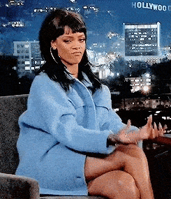 Rihanna making hand gestures for money